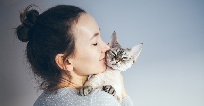 Junge Frau kuschelt mit ihrer Katze | Credit: iStock.com/insonnia