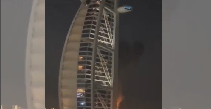 Das brennende Burj Al Arab Hotel in Dubai bei Nacht nach einem Drohnenangriff mit sichtbaren Feuersäulen an der Fassade