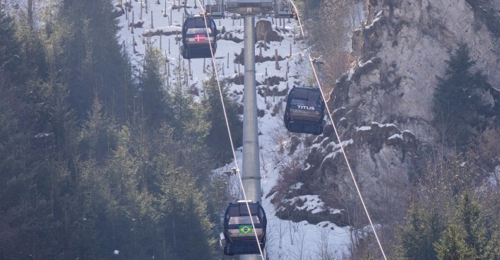 Gondelbahn im Skigebiet Engelberg-Titlis in der Schweiz mit mehreren Kabinen vor verschneitem Berghang