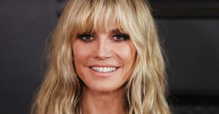Heidi Klum mit blondem, schulterlangem Haar und Pony. Das Model lächelt direkt in die Kamera vor dunklem Hintergrund. / Heidi Klum holt Beatrice Egli zu „Germany’s Next Topmodel“ (GNTM 2026).
