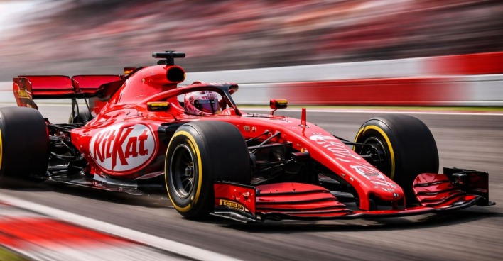Roter Formel-1-Rennwagen mit KitKat Branding auf der Rennstrecke als Symbol für das KitKat Gewinnspiel in Österreich