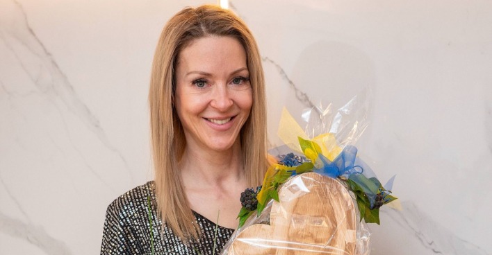 Simone Lugner lächelt und hält ein Geschenk in den Händen bei ihrer Geburtstagsfeier