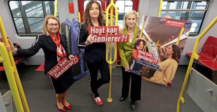 Drei Frauen mit Kampagnen-Schilder in einer Wiener U-Bahn