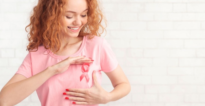 Frau mit rosa Schleife auf dem T-Shirt als Symbol für Brustkrebsbewusstsein