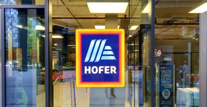 Eingang zu einer Hofer-Filiale mit Logo des Diskonters; Hofer führt im Fleisch-Sortiment mit Sonnenhof eine neue Marke ein