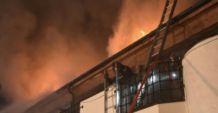 Feuerwehrmann löscht Dachbrand beim Klosterbräu Seefeld mit Leiter und Schlauch bei starkem Rauch