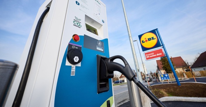 E-Auto lädt an einer Lidl-Ladesäule in Österreich; im Hintergrund das Lidl-Logo