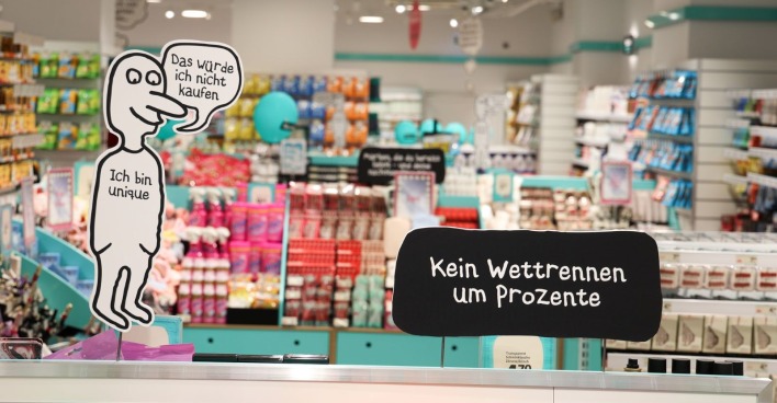 Innenansicht eines Normal Stores in Wien mit bunten Regalen, Beauty-Produkten und Hinweisen zum Fixpreis-Konzept ohne Rabattaktionen