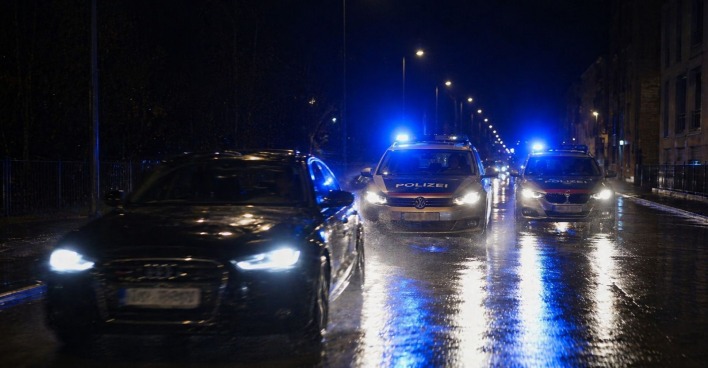 Polizeiautos verfolgen nachts einen schwarzen Audi bei nasser Fahrbahn in Wien-Döbling während einer Raser-Verfolgungsjagd.
