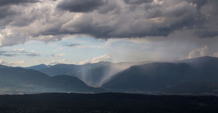 Dunkle Wolken über Bergland.