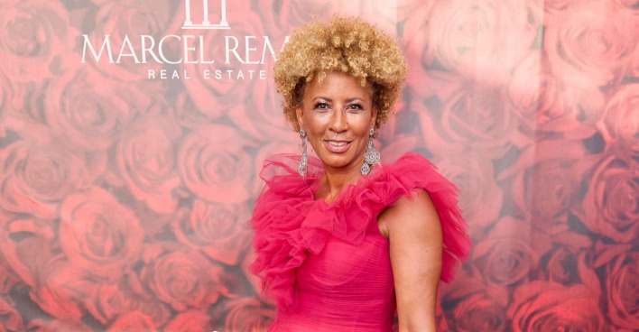 Arabella Kiesbauer posiert in einem pinken Kleid auf einem roten Teppich. Die Moderatorin steht aktuell wegen der Aussagen von Kader Loth nach „Kampf der RealityAllstars“ in den Schlagzeilen.