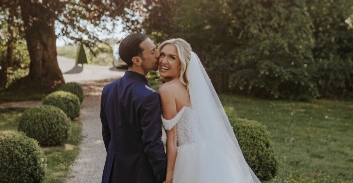 Danilo Campisi und Corinna Kamper bei ihrer romantischen Hochzeit in der Steiermark – das Brautpaar posiert glücklich nach der emotionalen Trauung im Garten der Hochzeitslocation.