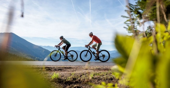 Zwei Menschen fahren auf Rädern durch die Landschaft