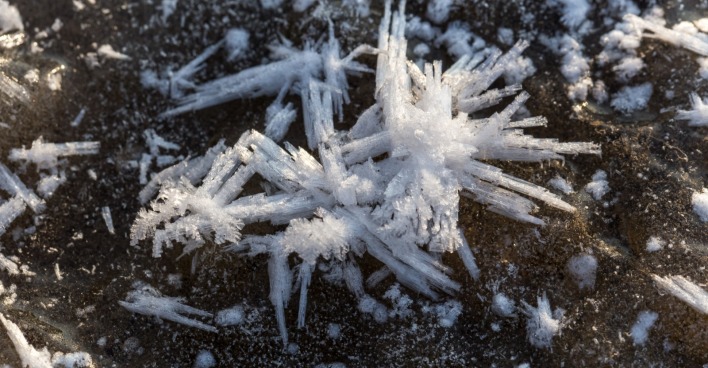 Eis und Schnee zu sehen auf einem winterlichen Boden.