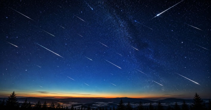 Sternschnuppen am klaren Nachthimmel über einer Landschaft während des Meteorstroms der Eta-Aquariiden im Mai