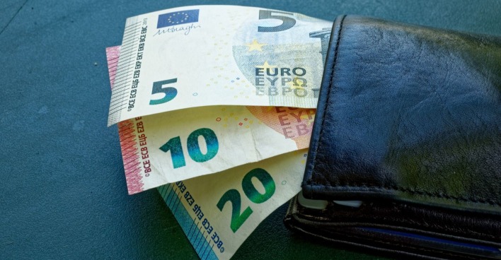 Geldbörse mit Euro-Scheinen und Münzen symbolisiert neue E-Card-Gebühren für Pensionisten und steigende finanzielle Belastung.