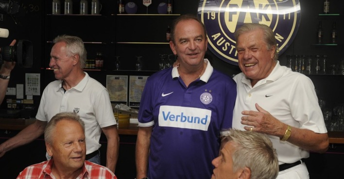 Hans Buzek mit ehemaligen Fußballspielern bei einer Veranstaltung in Wien, lachend im Gespräch in einem Lokal