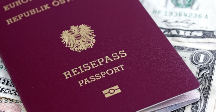 Österreichischer Reisepass im neuen Design mit Adler-Wappen auf Geldscheinen als Hintergrund, Symbol für Sicherheit und internationale Reisefreiheit