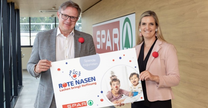 Zwei Menschen halten ein Schild in die Höhe