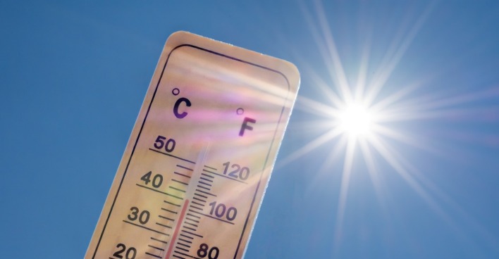 Thermometer mit hoher Temperatur in Grad Celsius und Fahrenheit mit einer strahlenden Sonne als Symbol für den Siebenschläfertag.