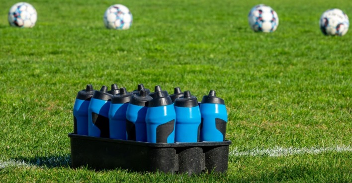 Mehrere Wasserflaschen auf einem Fußballfeld als Symbolbild für die Hydration Break bei der WM 2026