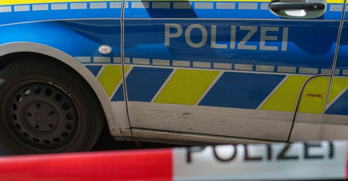 Polizeifahrzeug bei Einsatz nach Amoklauf an Schule in Bayern mit Absperrband im Vordergrund
