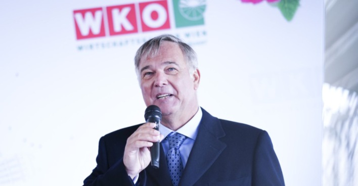 Walter Ruck bei einer Rede vor WKÖ-Logo im Hintergrund, im Fokus der aktuellen Debatte um umstrittene Aussagen und Rücktrittsforderungen