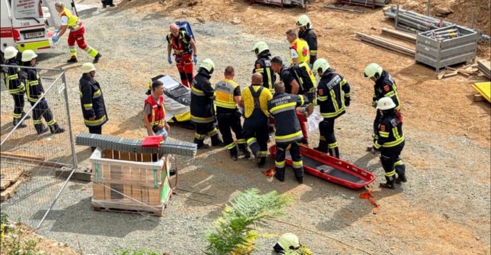 Feuerwehr und Rettungskräfte bei der Bergung eines Verletzten nach Baggerunfall auf Baustelle in Völkermarkt