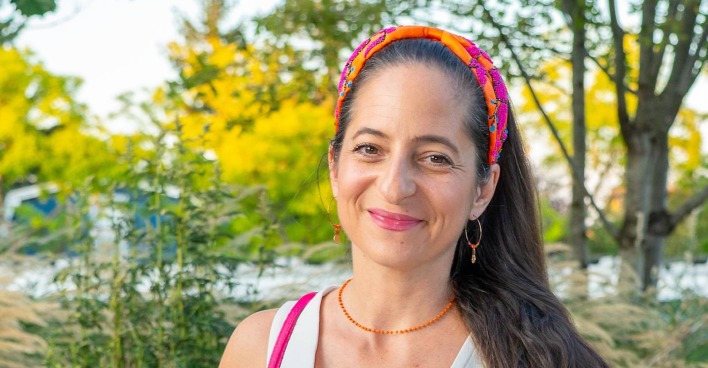 Caroline Athanasiadis lächelt im Freien mit buntem Haarband nach ihrer Operation