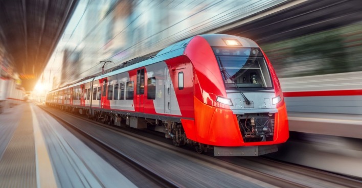 Ein roter Zug fährt in einen Bahnhof ein