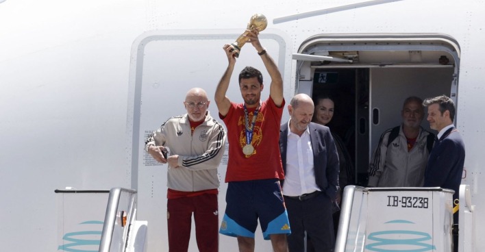Spaniens Kapitän Rodri hält nach der Rückkehr vom Fußball-WM-Finale gegen Argentinien den WM-Pokal am Flughafen in Madrid in die Höhe.