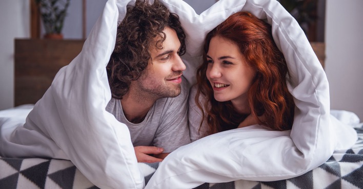 Frau und Mann unter der Bettdecke | Credit: George Rudy/Shutterstock