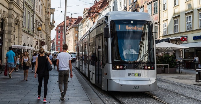 Eine Straßenbahn der Linie 1 fährt durch die Straßen von Graz