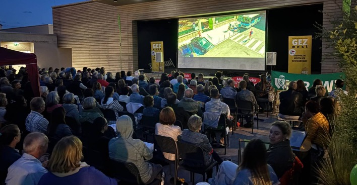 Ein voll besetzter Publikumsbereich vor der Open-Air-Kinoleinwand im GEZ west