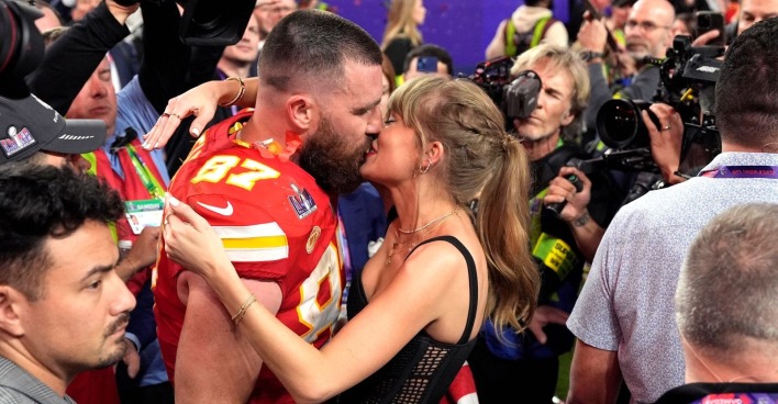 Taylor Swift küsst Travis Kelce.