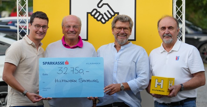 Vier Teilnehmer eines Golfturniers posieren mit einem Spendenscheck für ein Gruppenfoto | Credit: Hilfswerk Salzburg