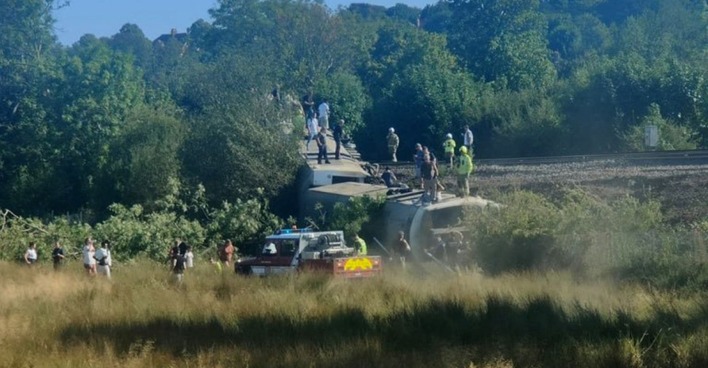Entgleister Zug nahe Lewes in East Sussex mit Rettungskräften und Menschen an der Unfallstelle