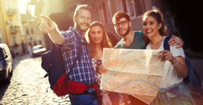 Junge Reisegruppe mit Stadtplan unterwegs | Credit: NDABCREATIVITY/Adobe Stock