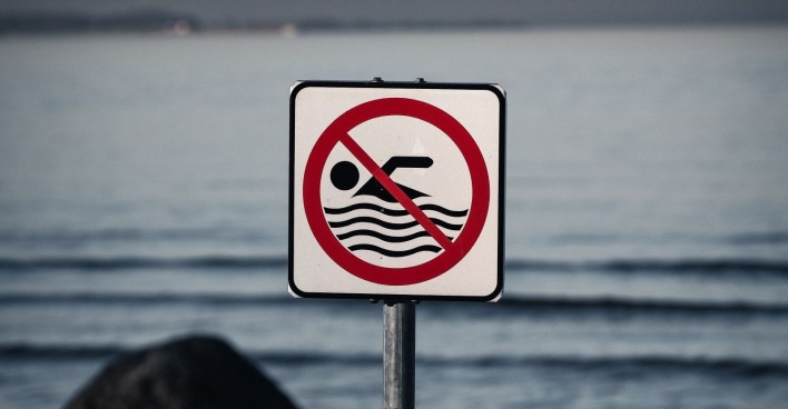 Badeverbot-Schild an einem Badesee in Österreich wegen Blaualgenbefalls und gesundheitsschädlicher Cyanobakterien.