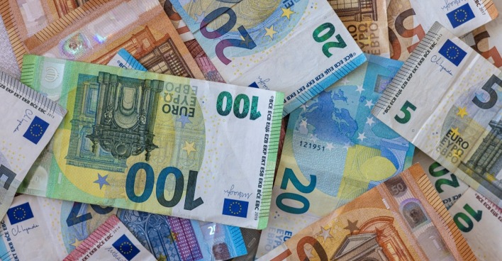 Farbiger Hintergrund mit Geld, Euro verschiedener Werte, als Symbolbild für die neuen Regeln mit dem Bargeld ab 2027.