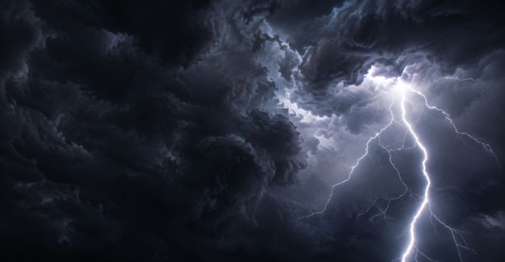 Dunkle Gewitterwolken und ein Blitz am Himmel