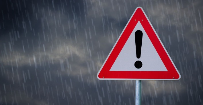 Unwetterwarnung in Österreich mit Warnschild bei starkem Regen und Gewittergefahr am Freitag.