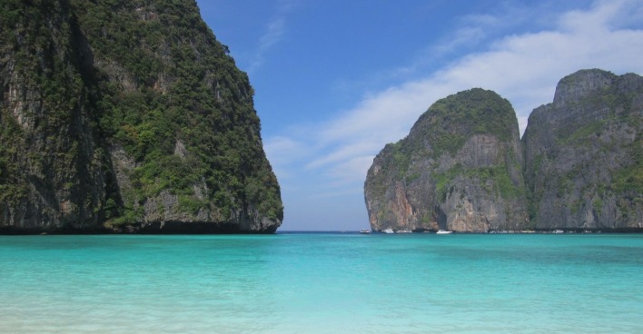 Türkisblaues Meer vor steilen Kalksteinfelsen in Thailand – traumhafte Küstenlandschaft in der Andamanensee, wo auch Würfelquallen (Seewespen) vorkommen können.