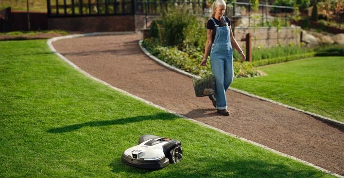 Frau im Garten mit Mähroboter | Credit: Husqvarna