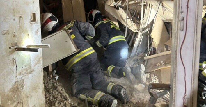 Feuerwehrleute suchen nach dem Hauseinsturz in der Wiener Färbergasse zwischen Trümmern und Mauerteilen.