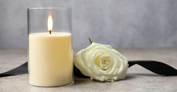 Brennende Trauerkerze und weiße Rose zum Tod von Andreas Fillei, Bürgermeister von Treffen am Ossiacher See.