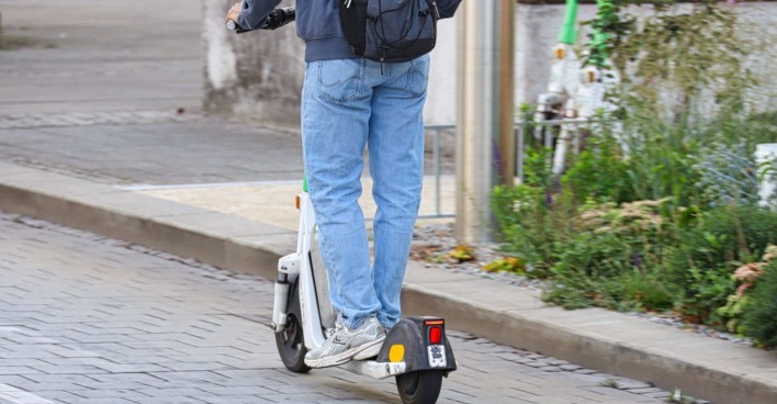 Jugendlicher fährt auf einem E-Scooter