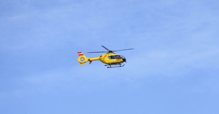 Gelber Rettungshubschrauber fliegt durch die Luft