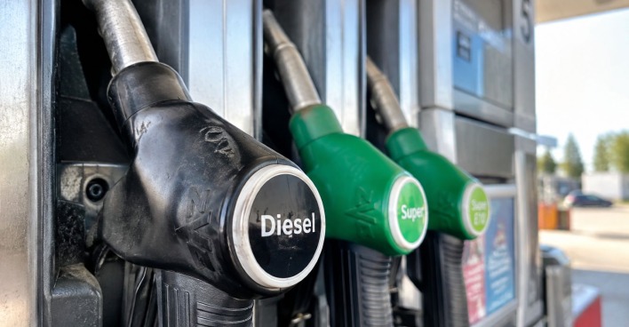 Nahaufnahme einer Zapfsäule mit Diesel- und Benzin-Zapfhähnen an einer Tankstelle