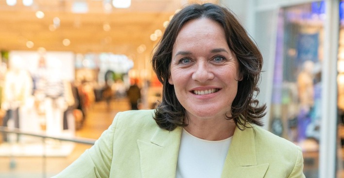 Eva Pölzl lächelt bei einem öffentlichen Auftritt in die Kamera.